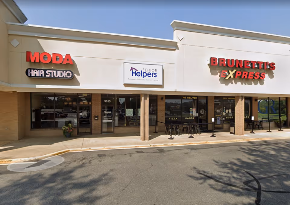 Exterior storefront view featuring Senior Helpers sign between Moda Hair Studio and Brunetti's Express.