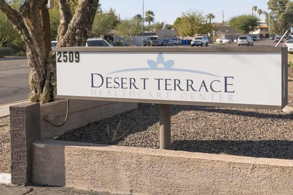 Desert Terrace Healthcare Center sign at the facility entrance with a parking lot visible