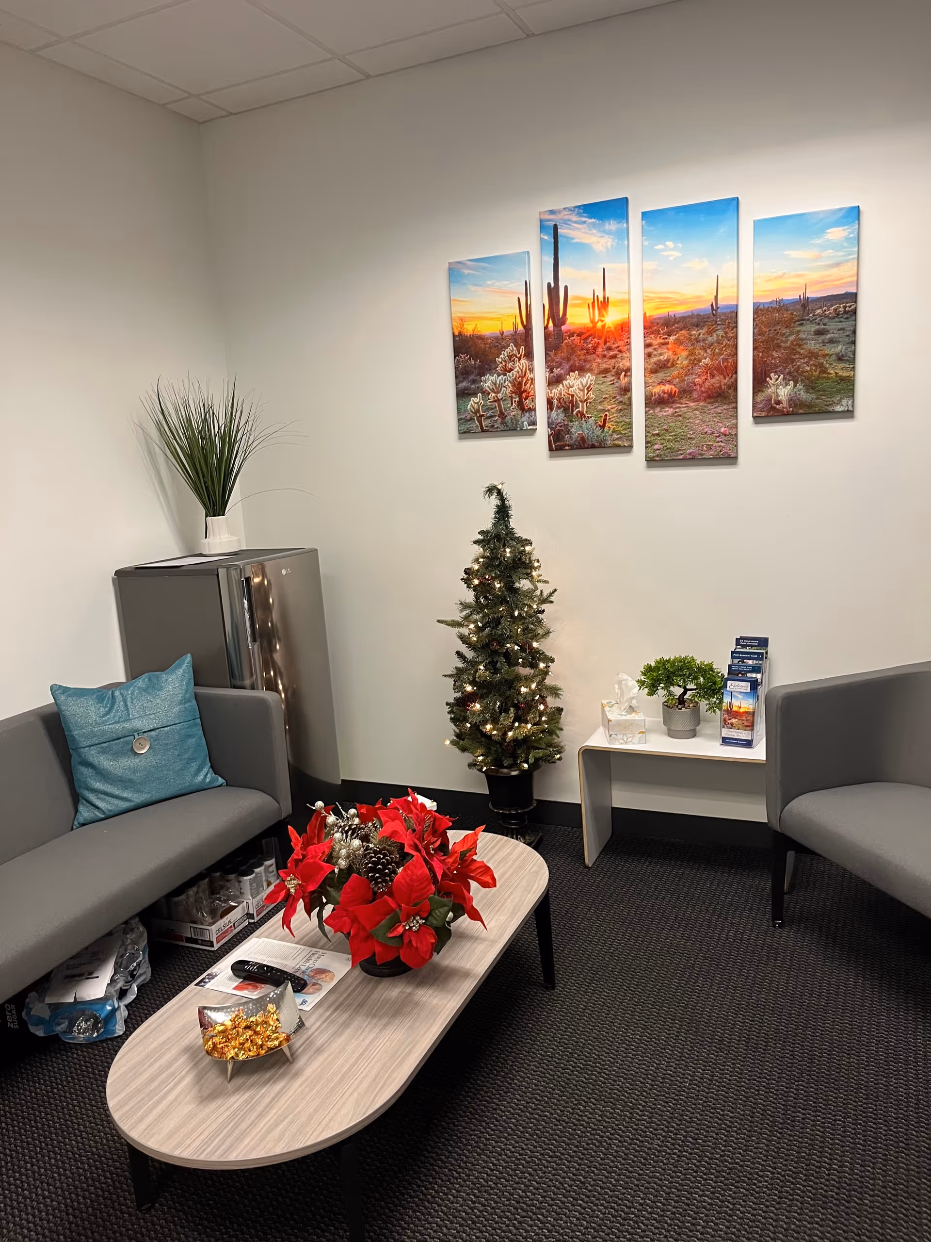 Endeavor In Home Care lobby lounge with gray seating, table, tree, and desert-themed art.