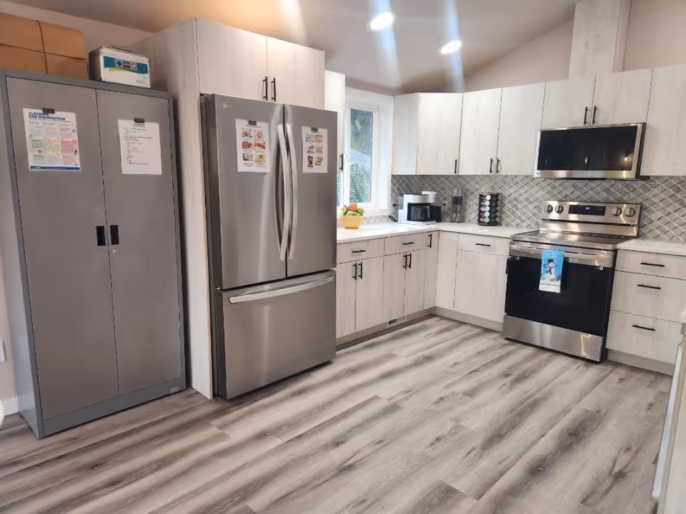 A modern kitchen with stainless steel appliances and light wood cabinets.