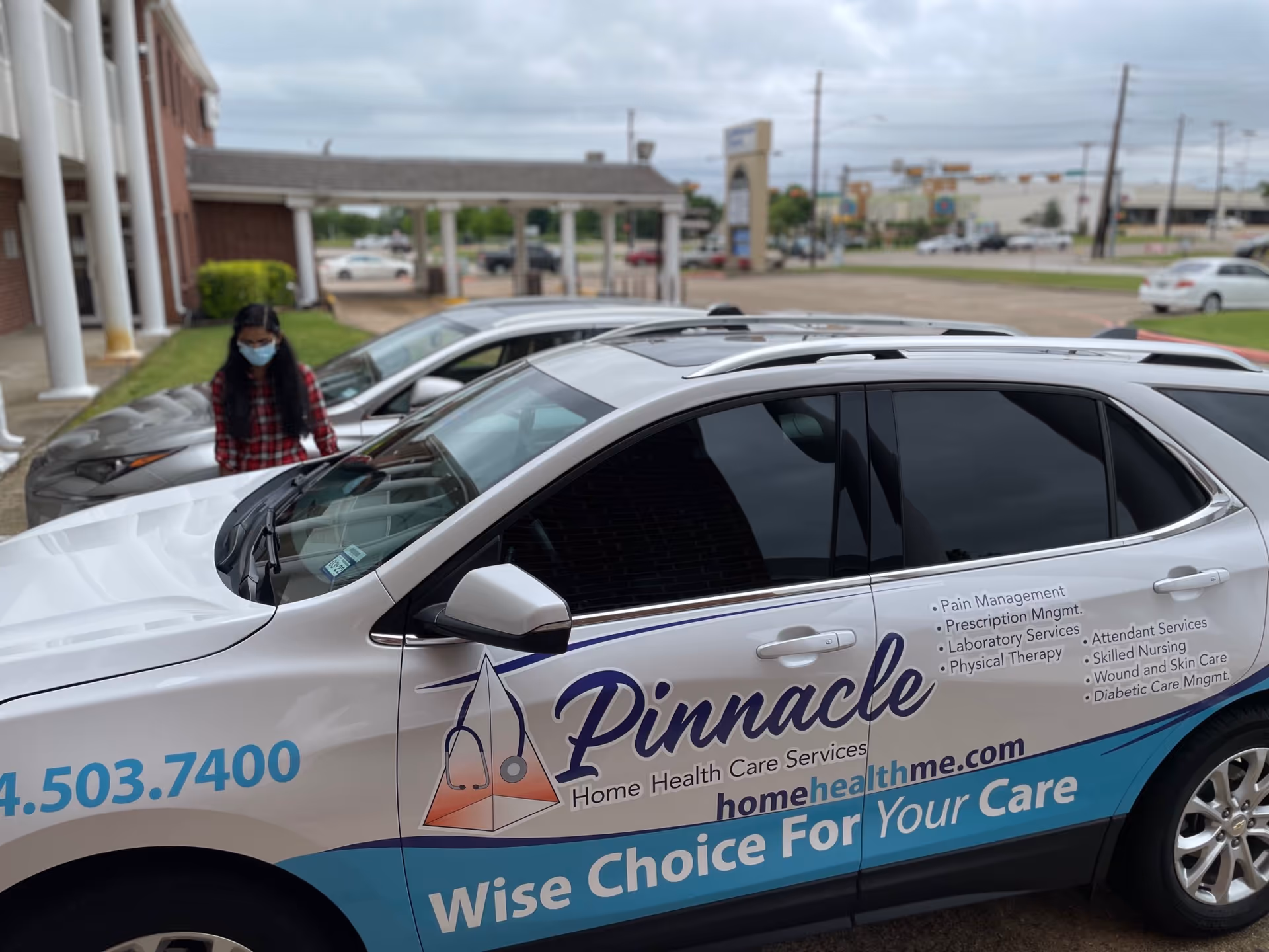 Pinnacle Home Health Care Services van parked outside a facility, with a masked person nearby.