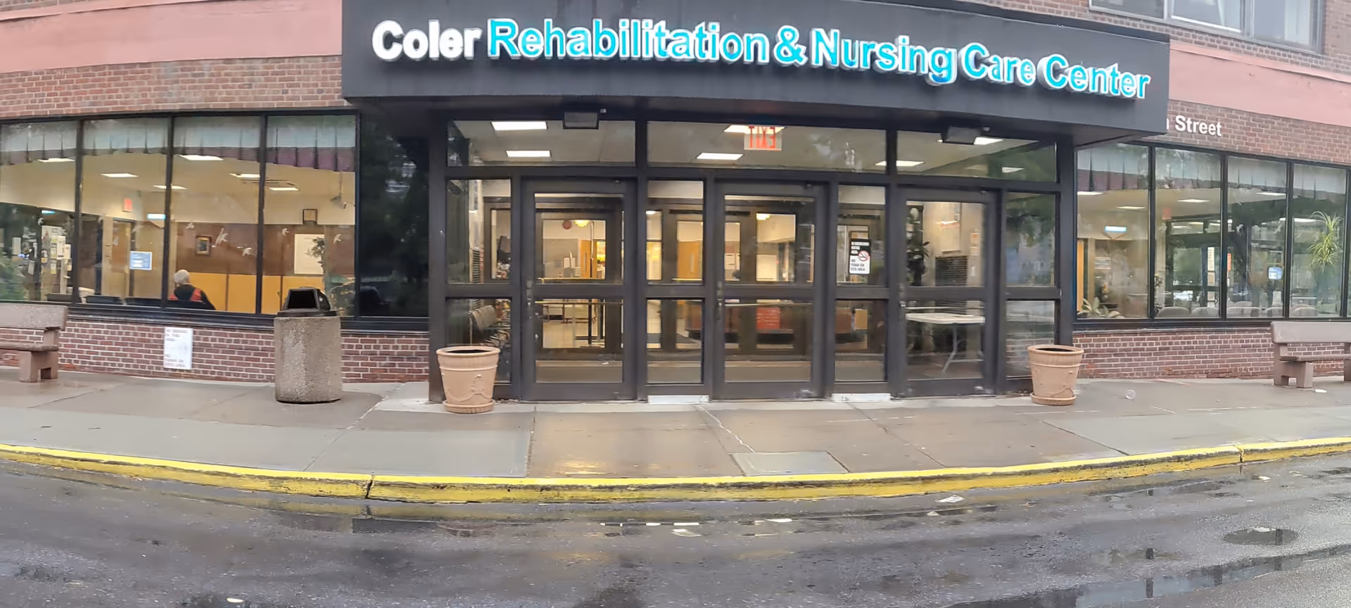 Front of Coler Rehabilitation and Nursing Care Center with glass entrance and storefront windows.