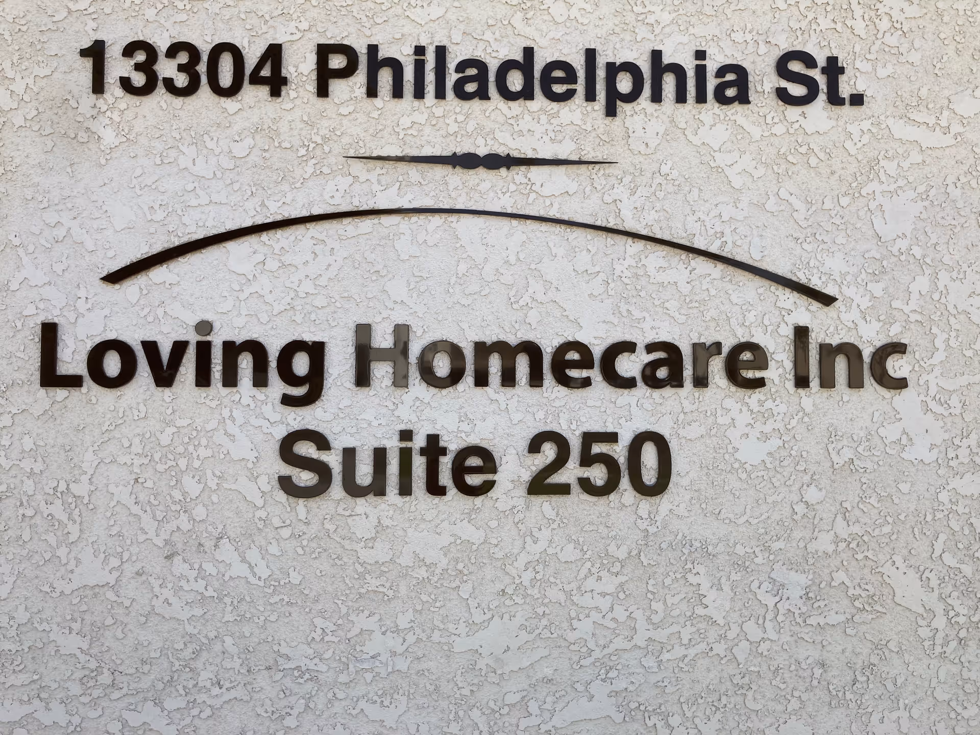 Exterior wall sign displaying Loving Homecare Inc and Suite 250