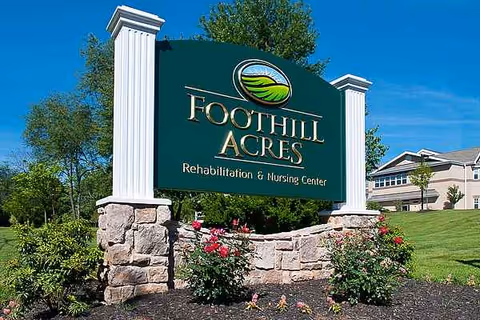 Foothill Acres Rehabilitation & Nursing Center sign with stone base and landscaped surroundings.