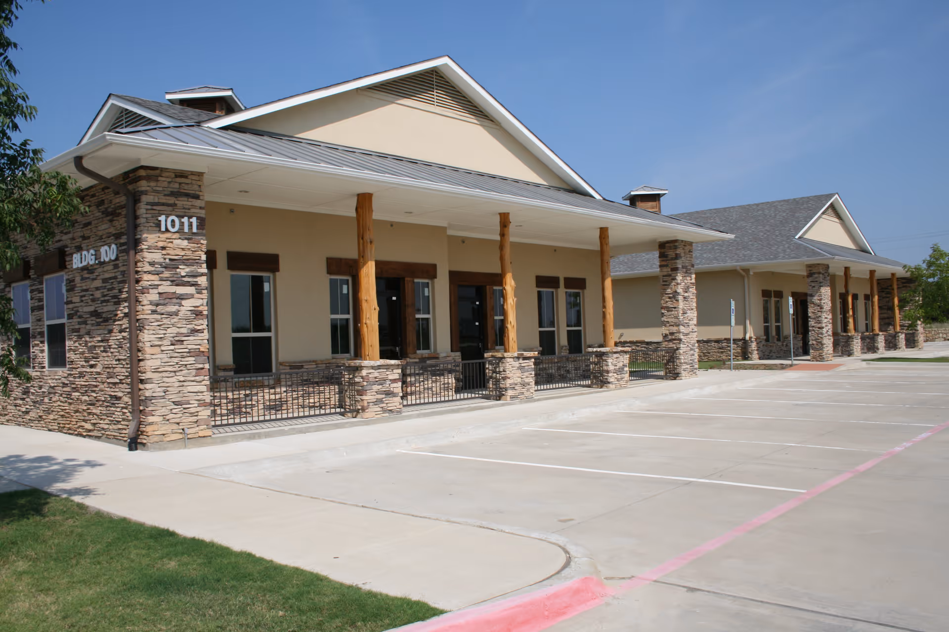 Exterior view of a single-story senior living facility with stone columns and a wide entrance.