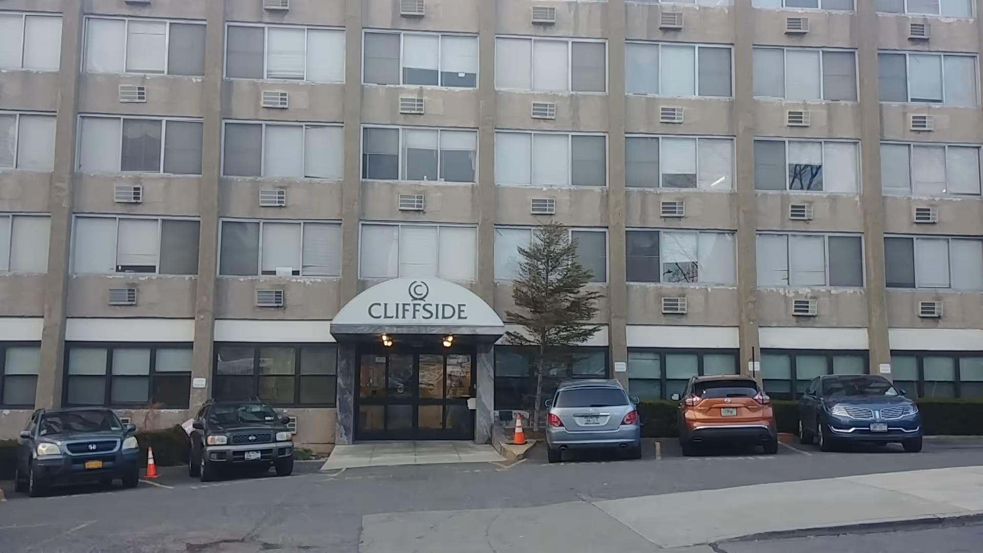 Front view of Cliffside Rehab & Residential Health Care Center entrance with canopy and parked cars