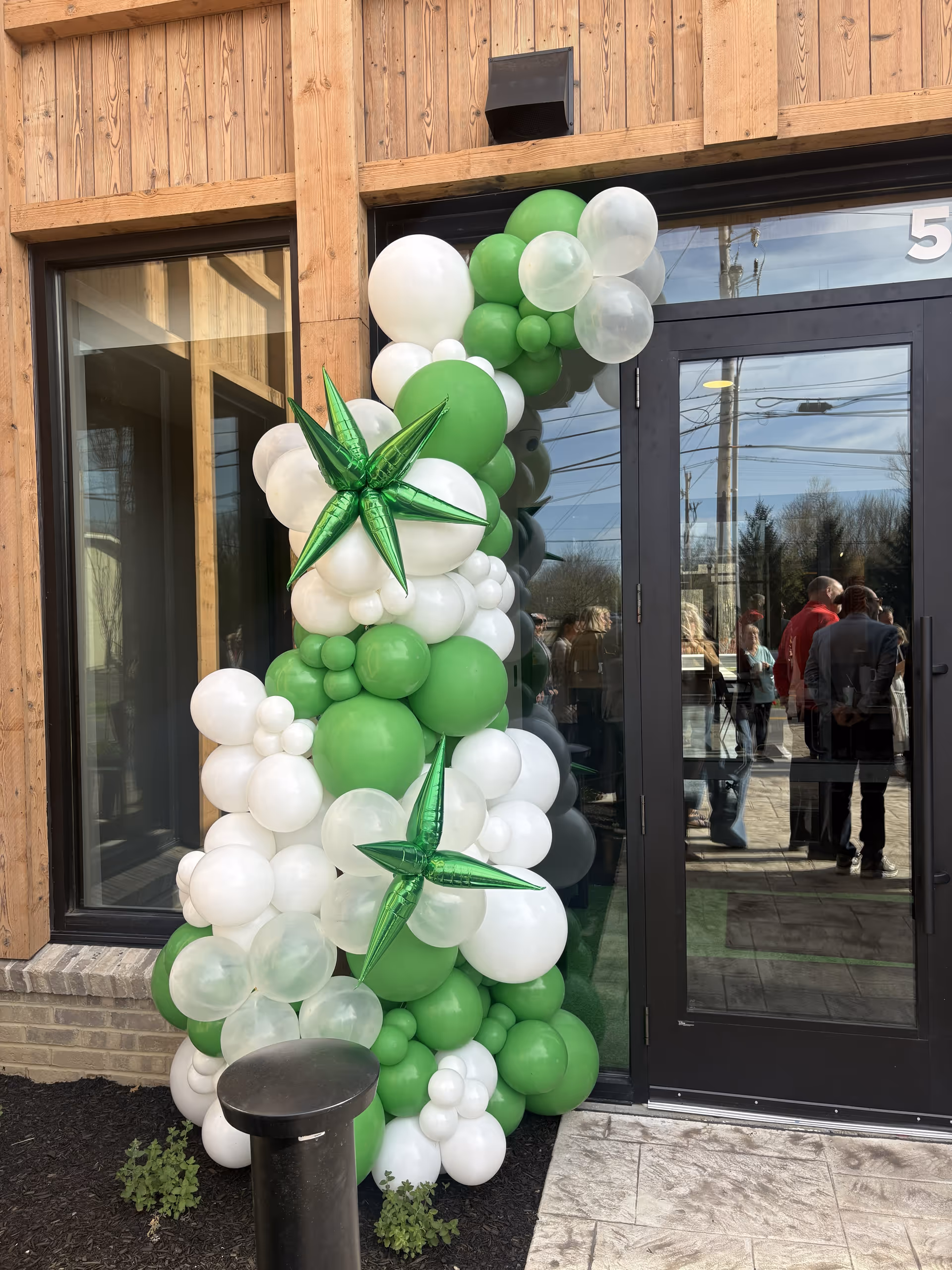 Exterior entrance with a green and white balloon arch at Home Helpers Home Care Delaware