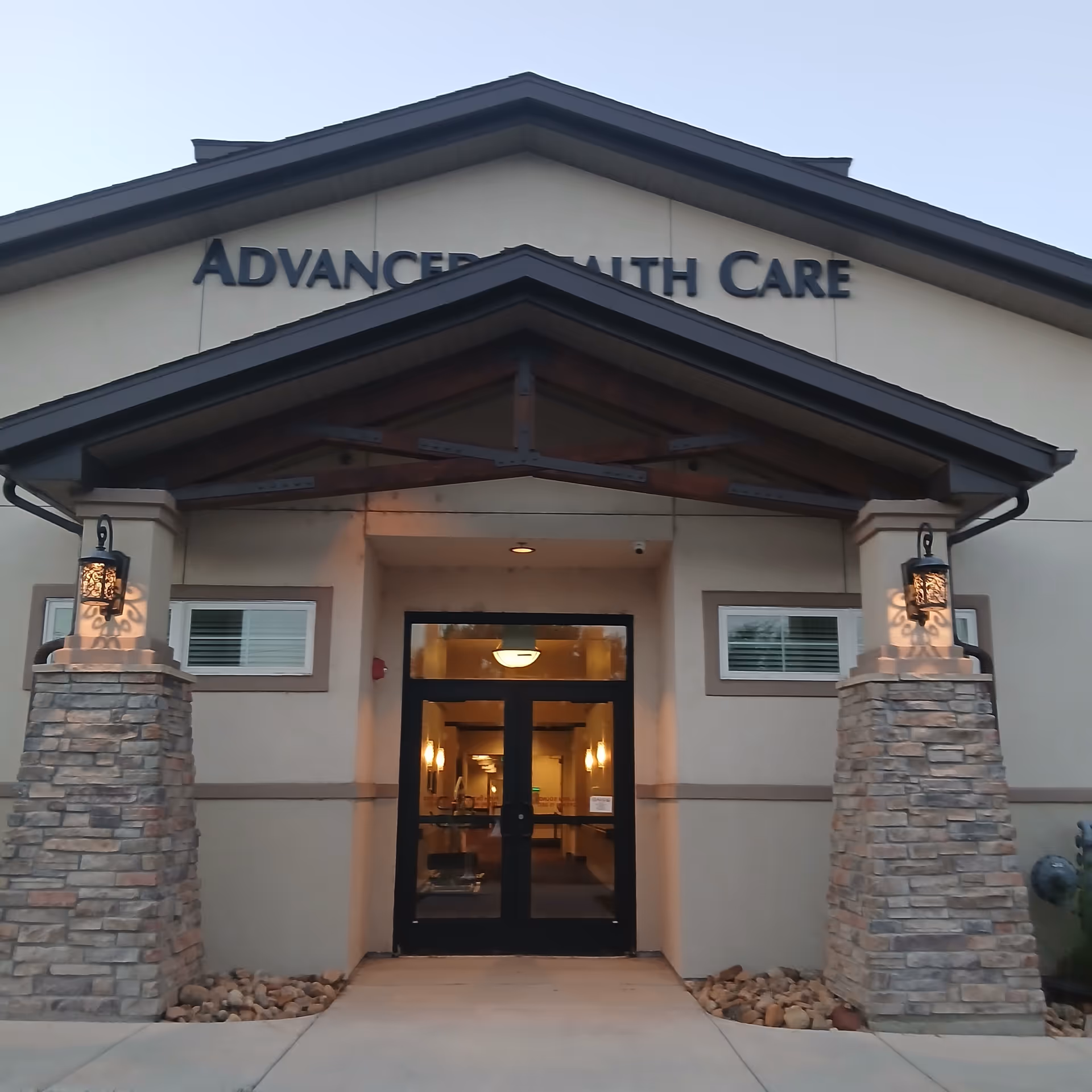 Front entrance of Advanced Health Care of Lakewood, with stone pillars and glass doors.