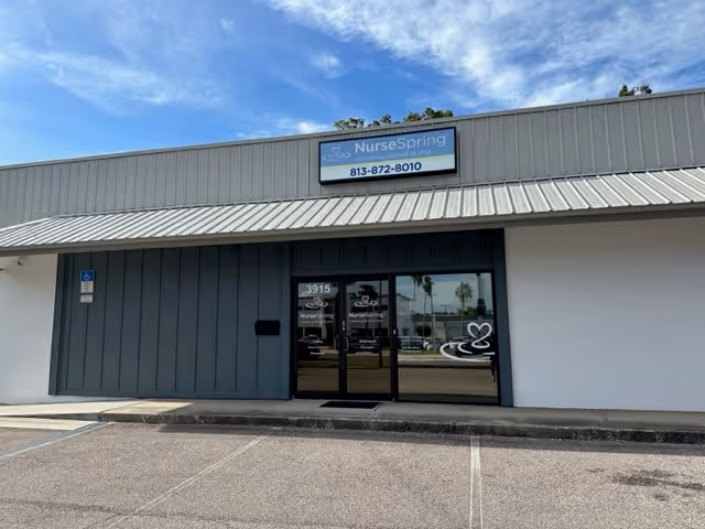 Front exterior of NurseSpring facility in Tampa with glass entrance and parking area.