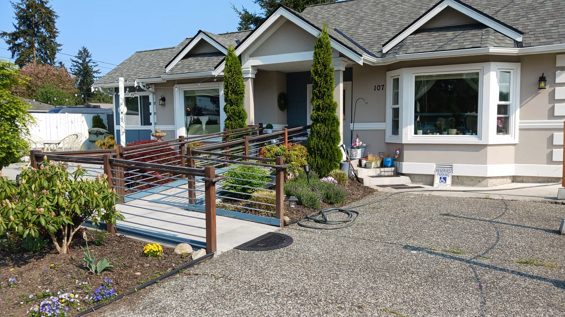 Single-story senior living facility exterior with ramp, landscaping, and front window.