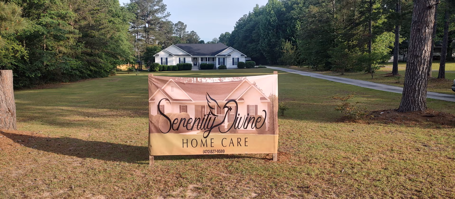 Serenity Divine Home Care banner stands on a grassy lawn with a house in the background.