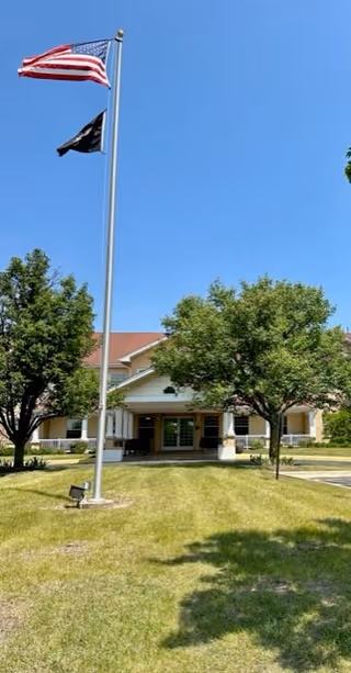 Exterior view of Allure of Zion senior living facility with flags.