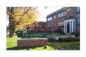 Brick building exterior with a sign reading 'The Marvin' and autumn trees.