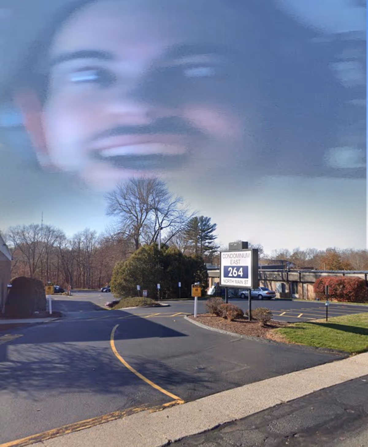 Exterior view shows a large, blurry face overlay in the sky above a senior living facility.