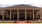 Front view of a single-story facility with a wide covered entrance and columns.