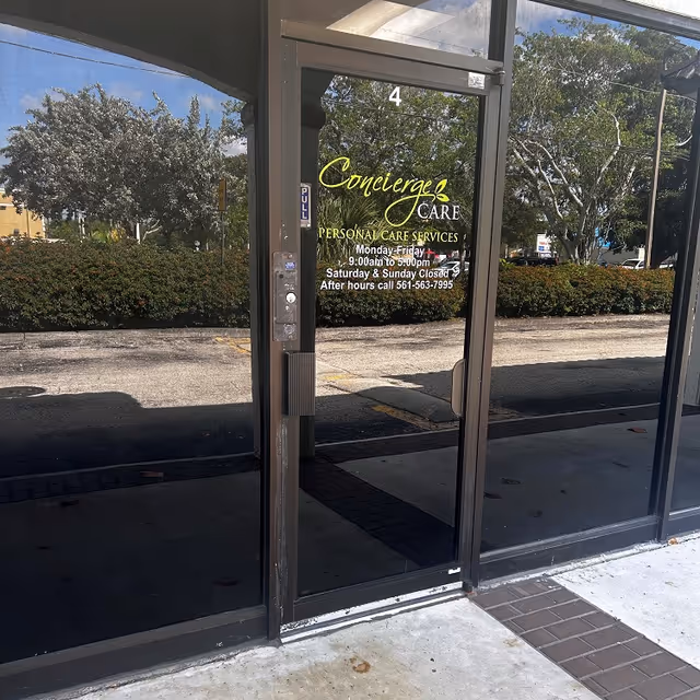 Front glass doors of Concierge Care with signage and exterior surroundings.