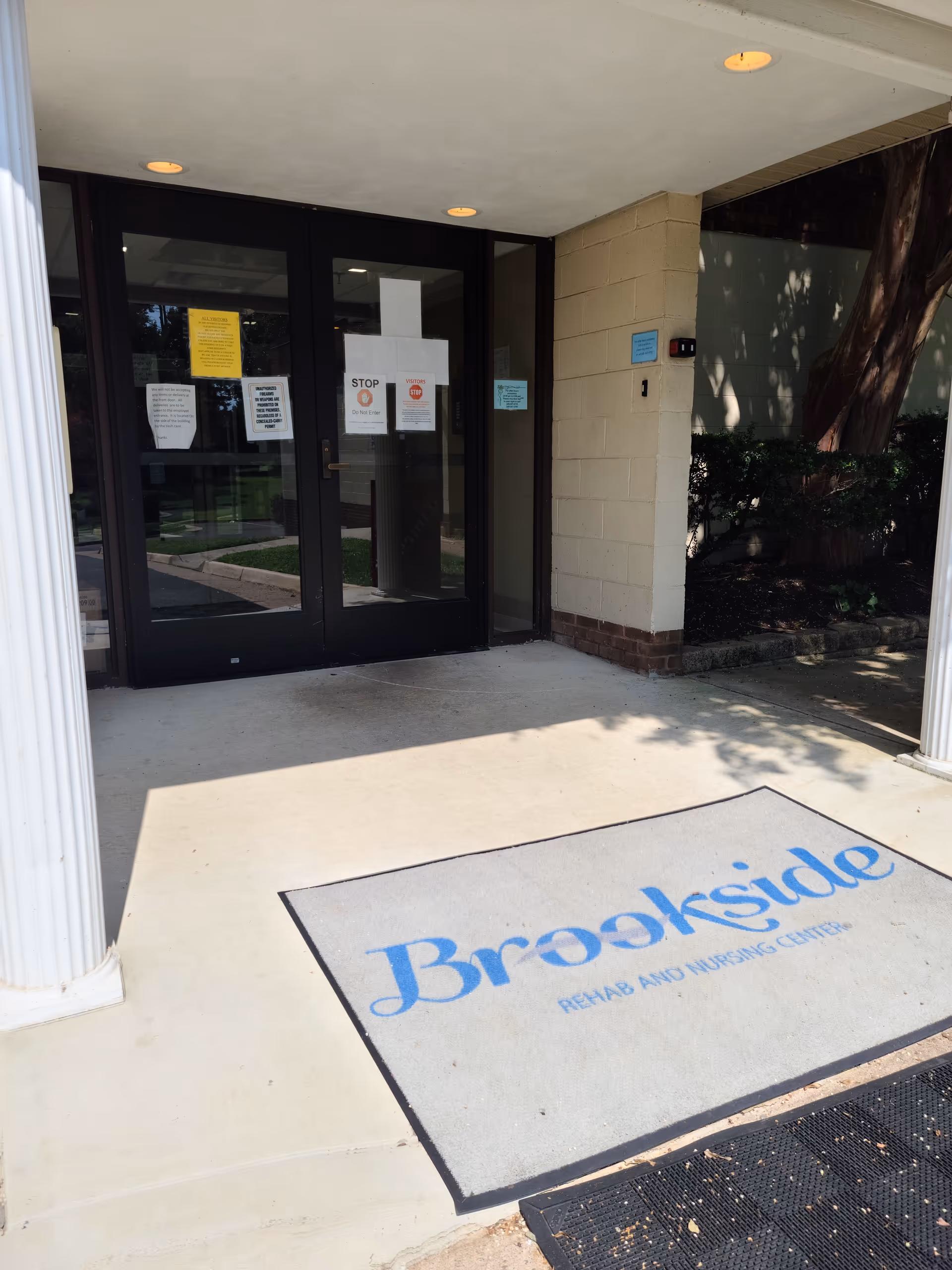 Entrance to Brookside Rehab and Nursing Center with glass doors and a Brookside mat.