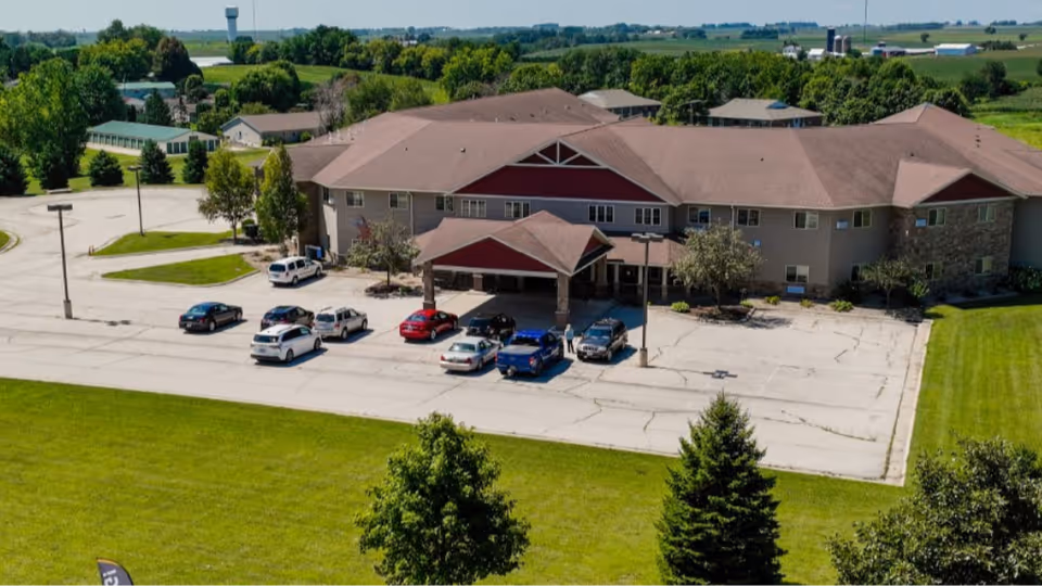 Aerial view of Copper Creek Senior Living building with parking lot and green lawn