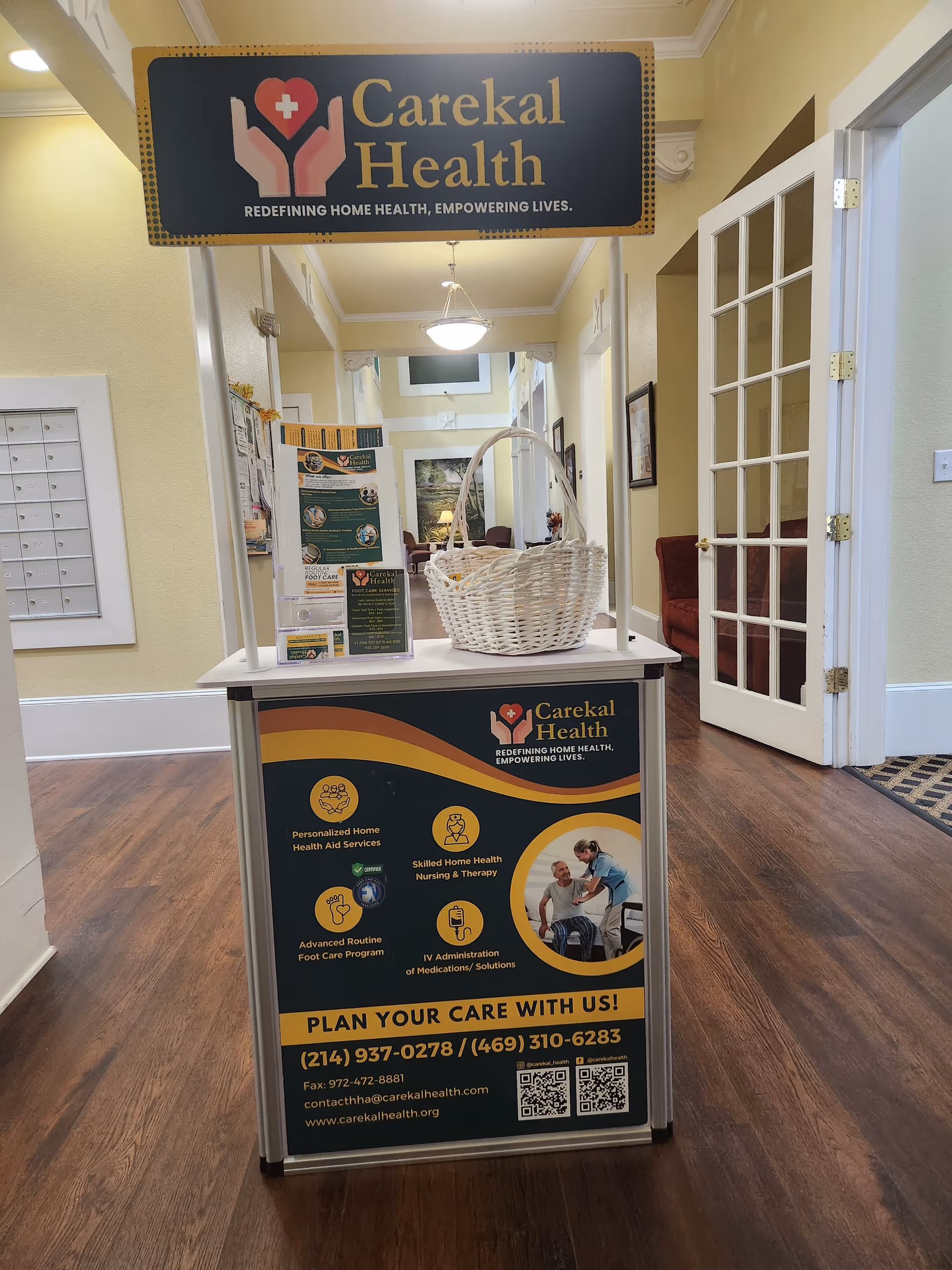 Interior hallway at Carekal Health with a front desk kiosk, basket, and banners.
