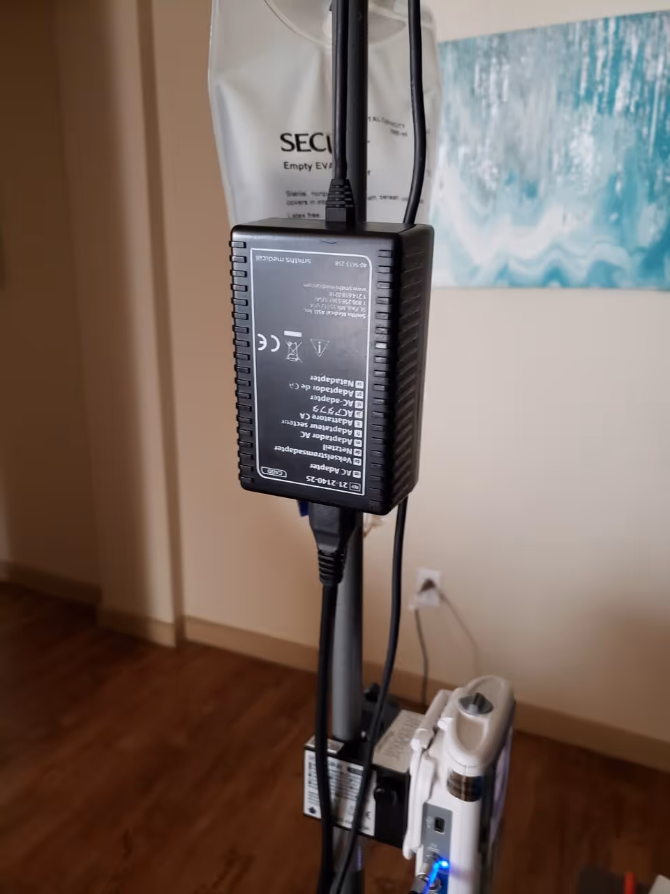 Medical device on a stand with cables in an interior room.