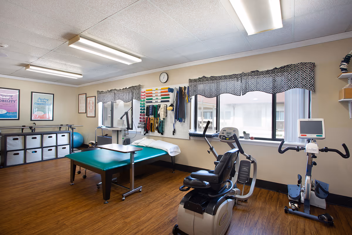 Therapy room inside Heritage Hall Dillwyn with a green treatment table and exercise equipment.