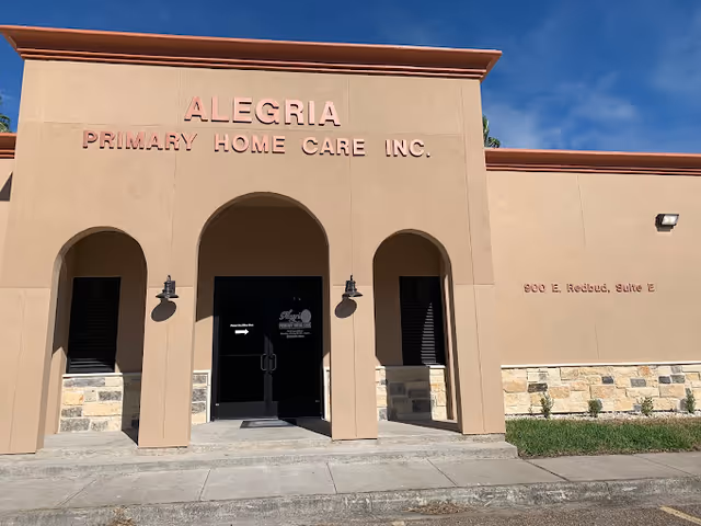 Beige Alegria Primary Home Care building exterior with arched entry and glass doors.