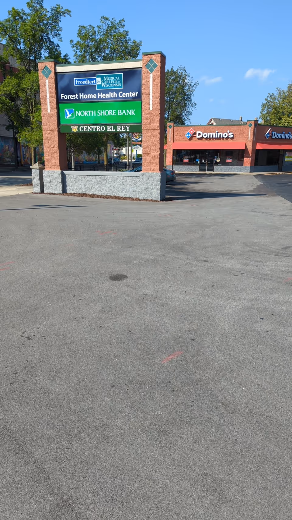 Brick sign structure lists Forest Home Health Center, North Shore Bank, Centro El Rey, and Domino's.