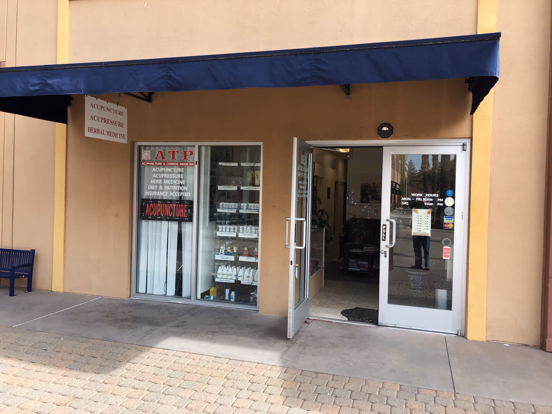 Storefront with blue awning, glass doors, and a sign reading ATP Acupuncture and Chinese Medicine Fremont.