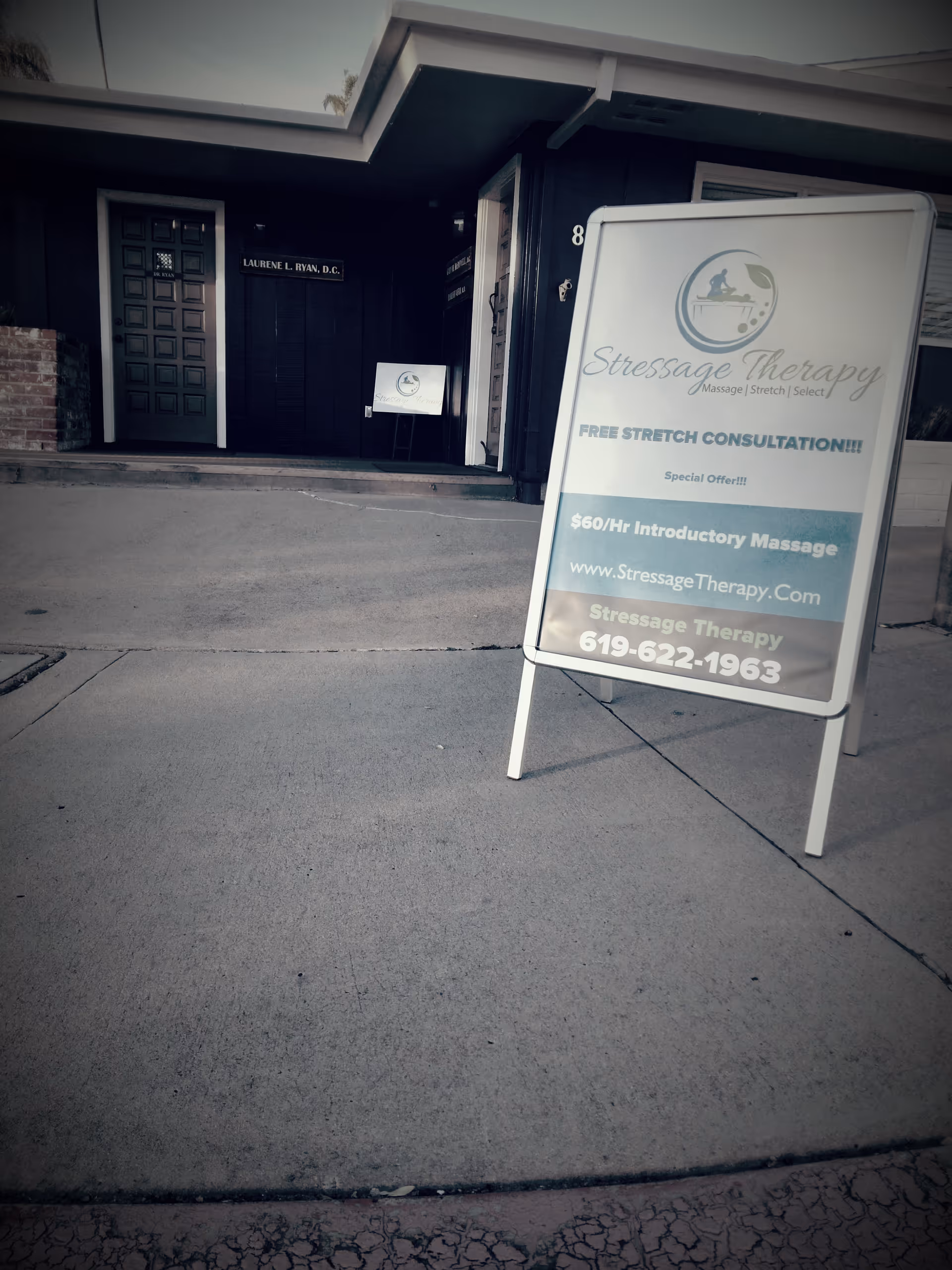 Exterior view of a storefront with a sidewalk sign for Stressage Therapy.