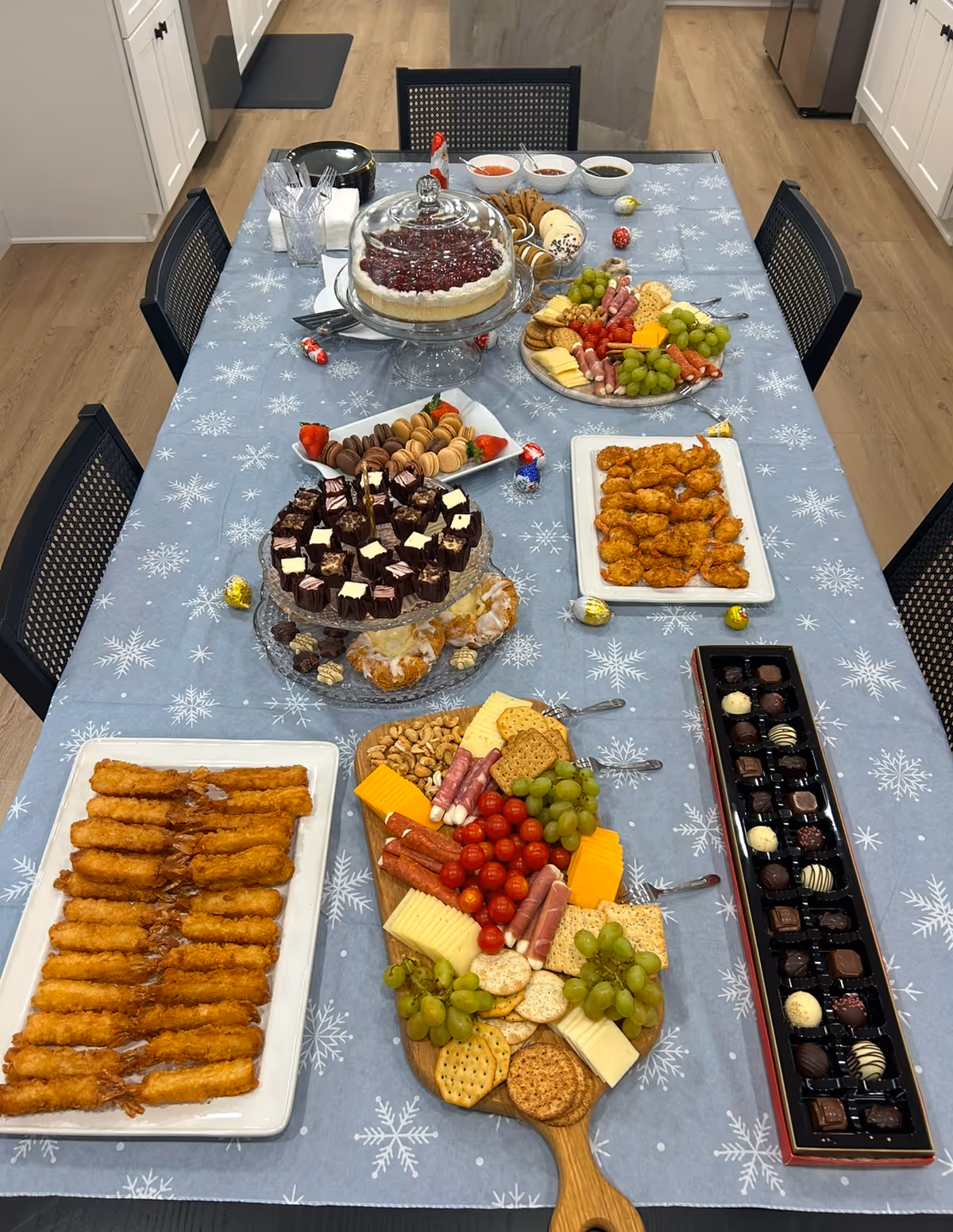 Long table laden with cheeses, fruit, chocolates, pastries, and desserts in Brighton Serenity Care dining area.