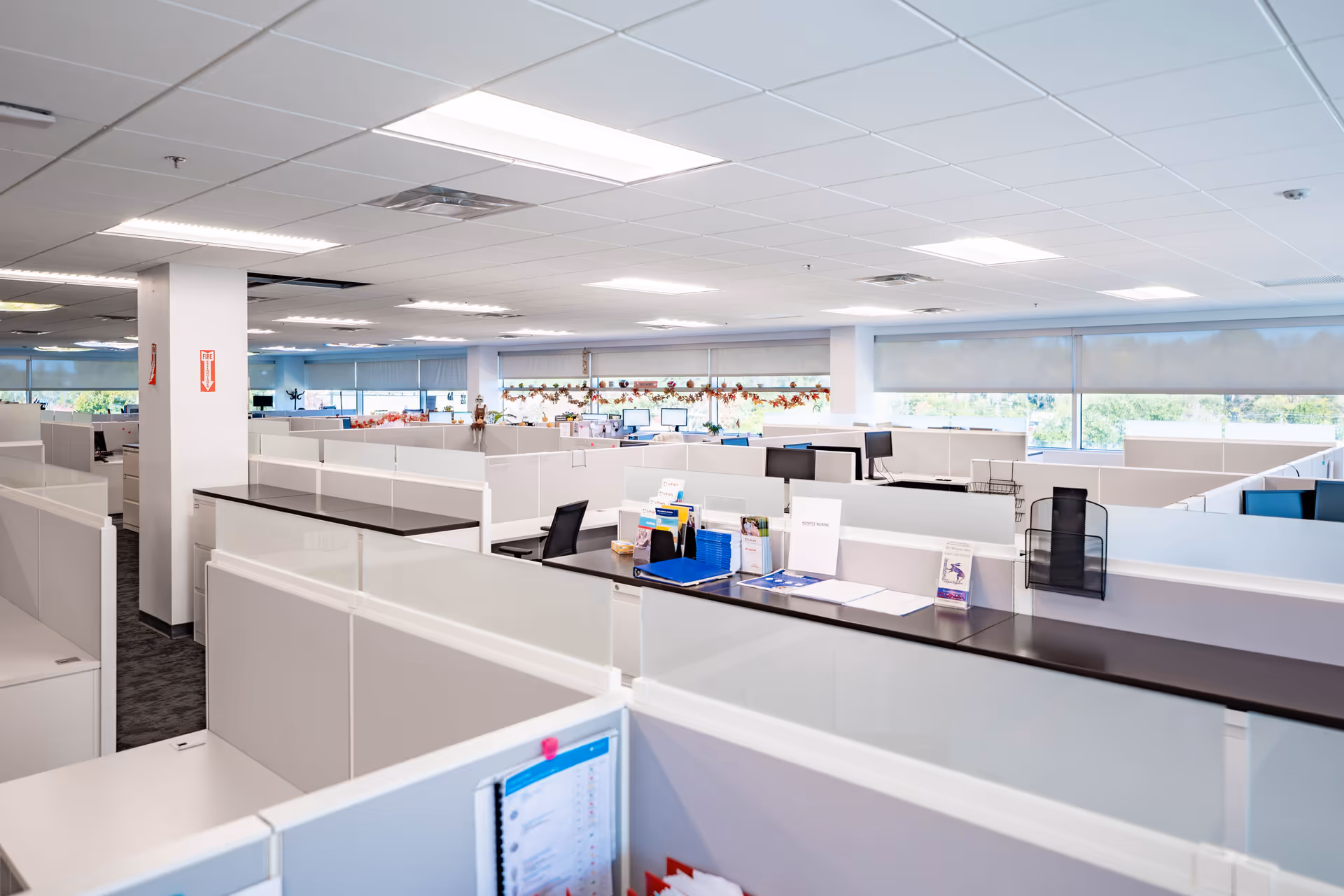 Open-plan office area with cubicles and desks inside a healthcare facility.