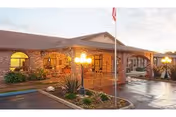 Exterior view of Westgate Gardens Care Center with brick facade, entrance, and a lit walkway.