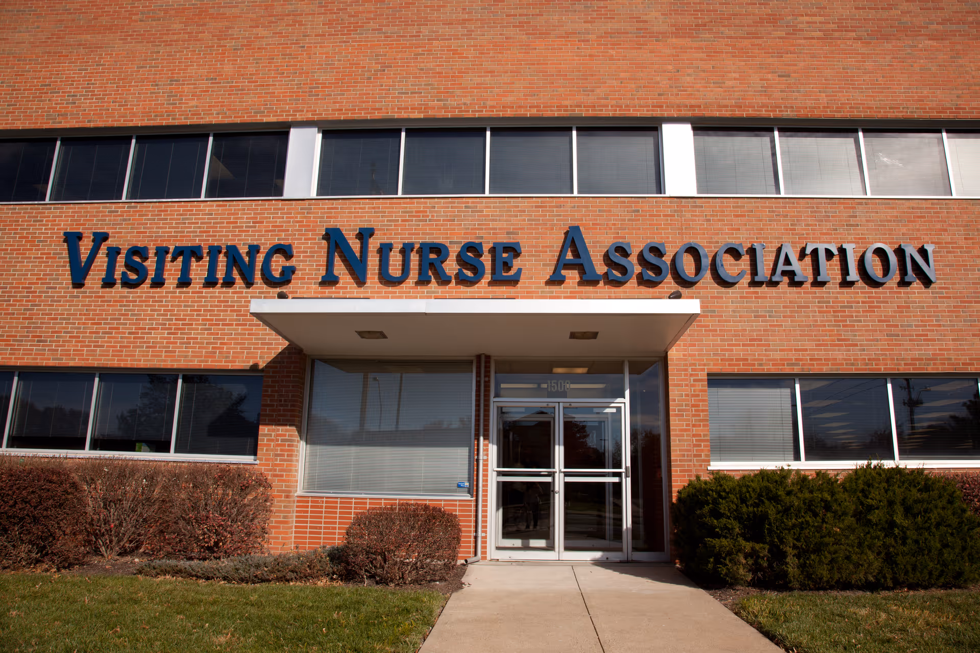 Front view of a brick building with Visiting Nurse Association signage and entrance.