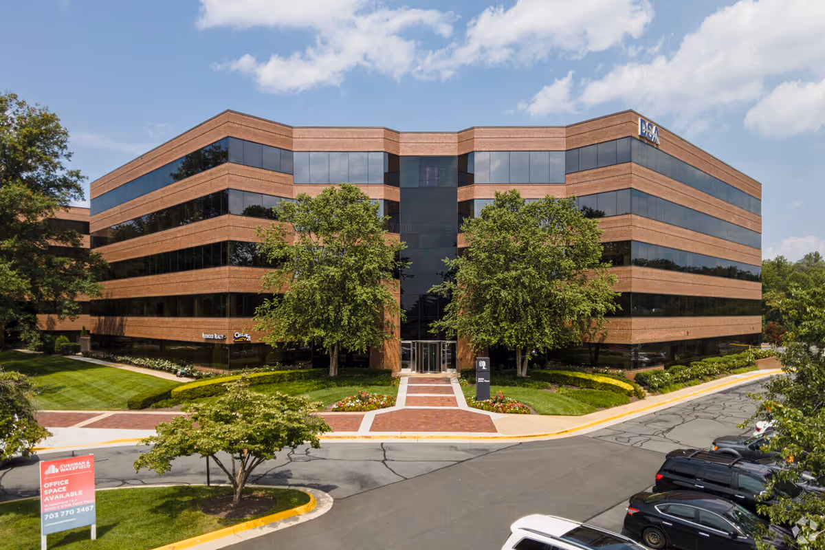 Exterior view of a brick-and-glass senior care building with a landscaped entrance.