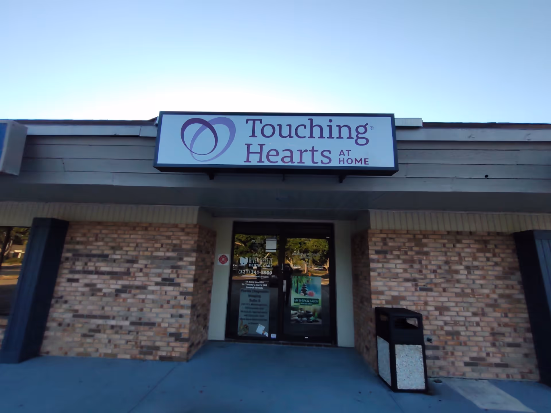 Front exterior of Touching Hearts at Home facility with entrance sign.