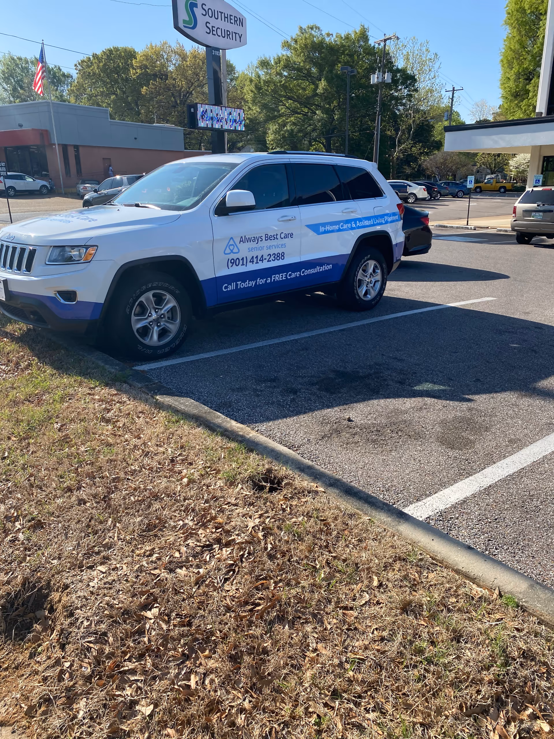 White SUV with Always Best Care signage parked outside a building.