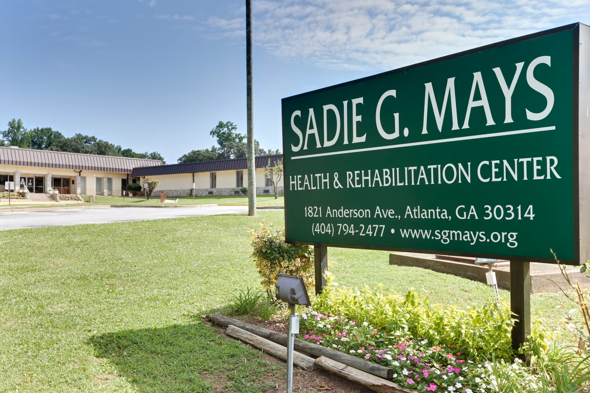 Green Sadie G. Mays Health & Rehabilitation Center sign with the building visible in the background.