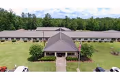 Aerial view of Camden Nursing Facility entrance with a central covered walkway and lawn.