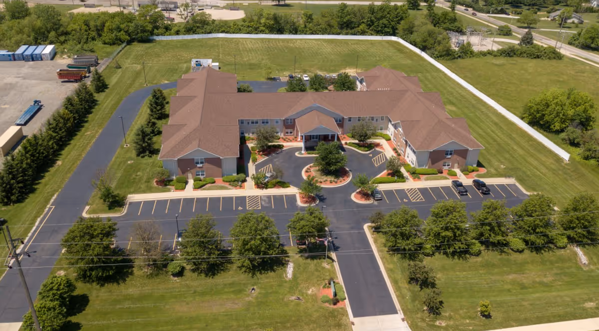 Aerial view of Brookstone Estates of Robinson, a multi-wing senior living campus with parking and lawns.