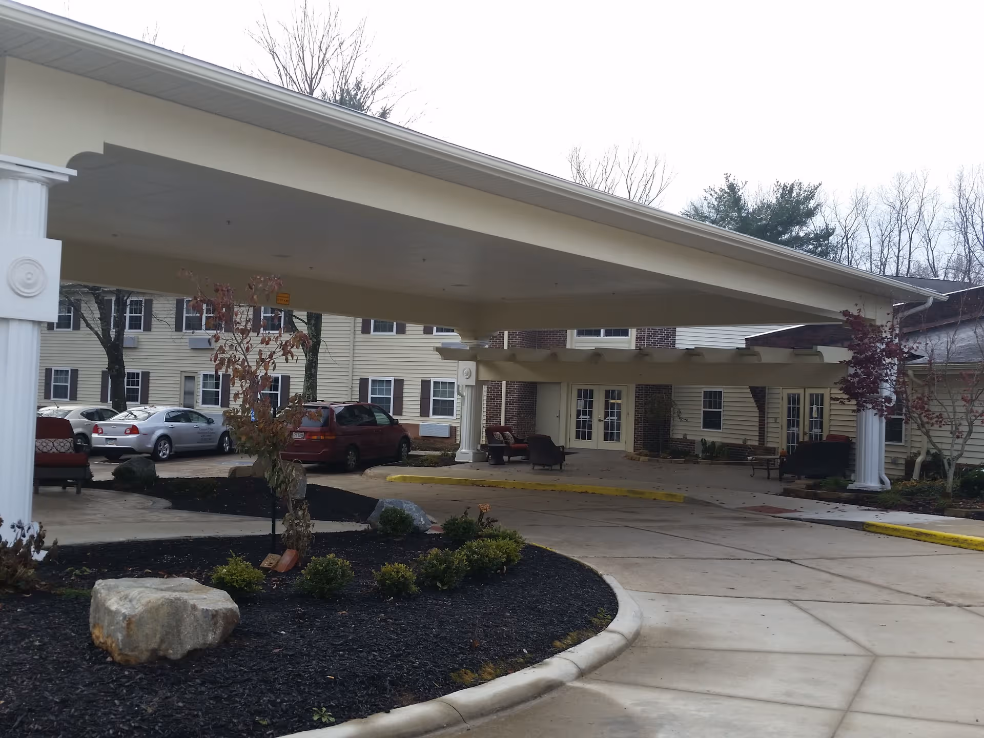 Exterior view of Country Club Rehabilitation Campus at Mt. Vernon with porte-cochere entrance and parked cars.