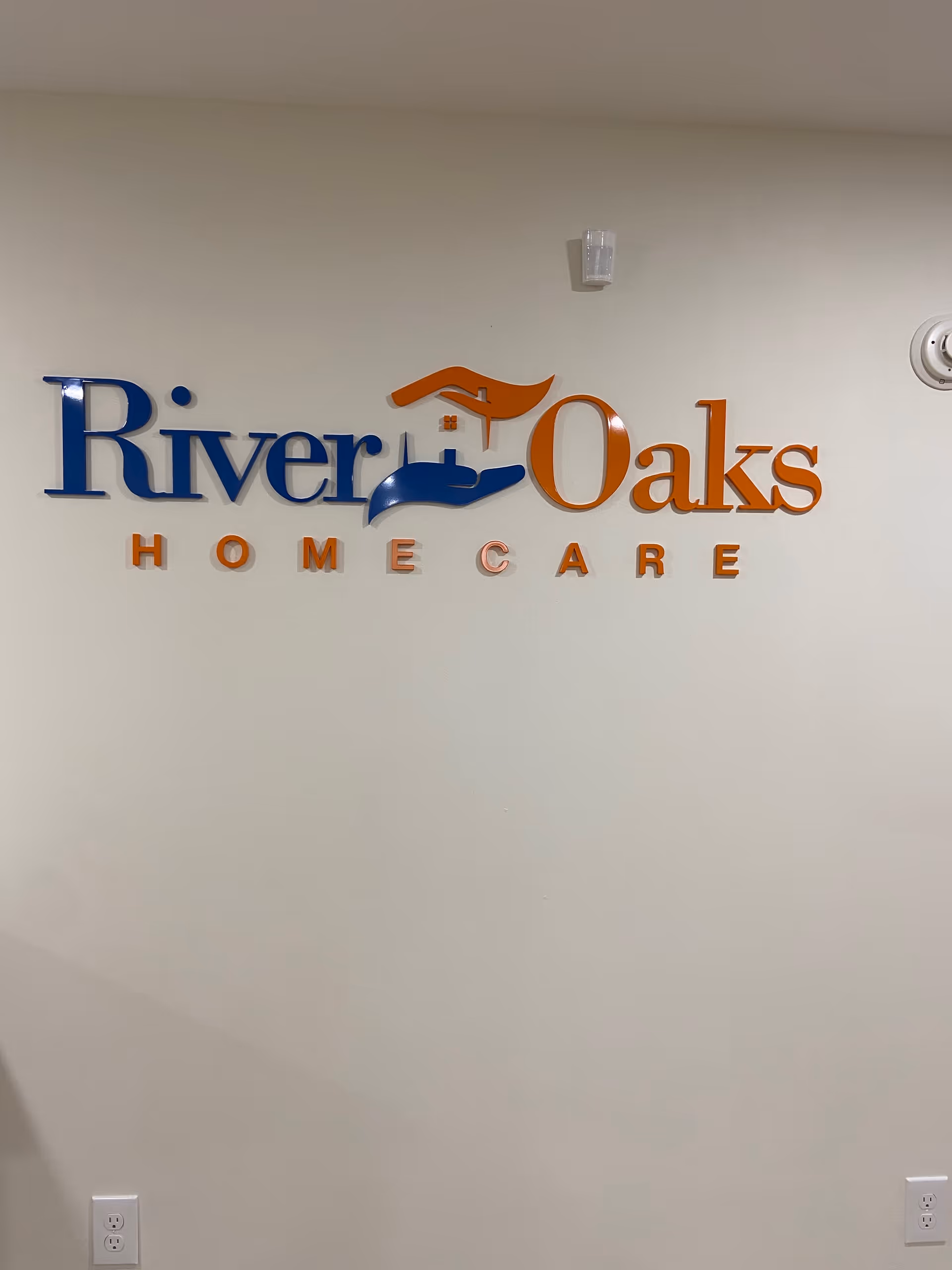 Interior wall with a River Oaks Home Care logo sign