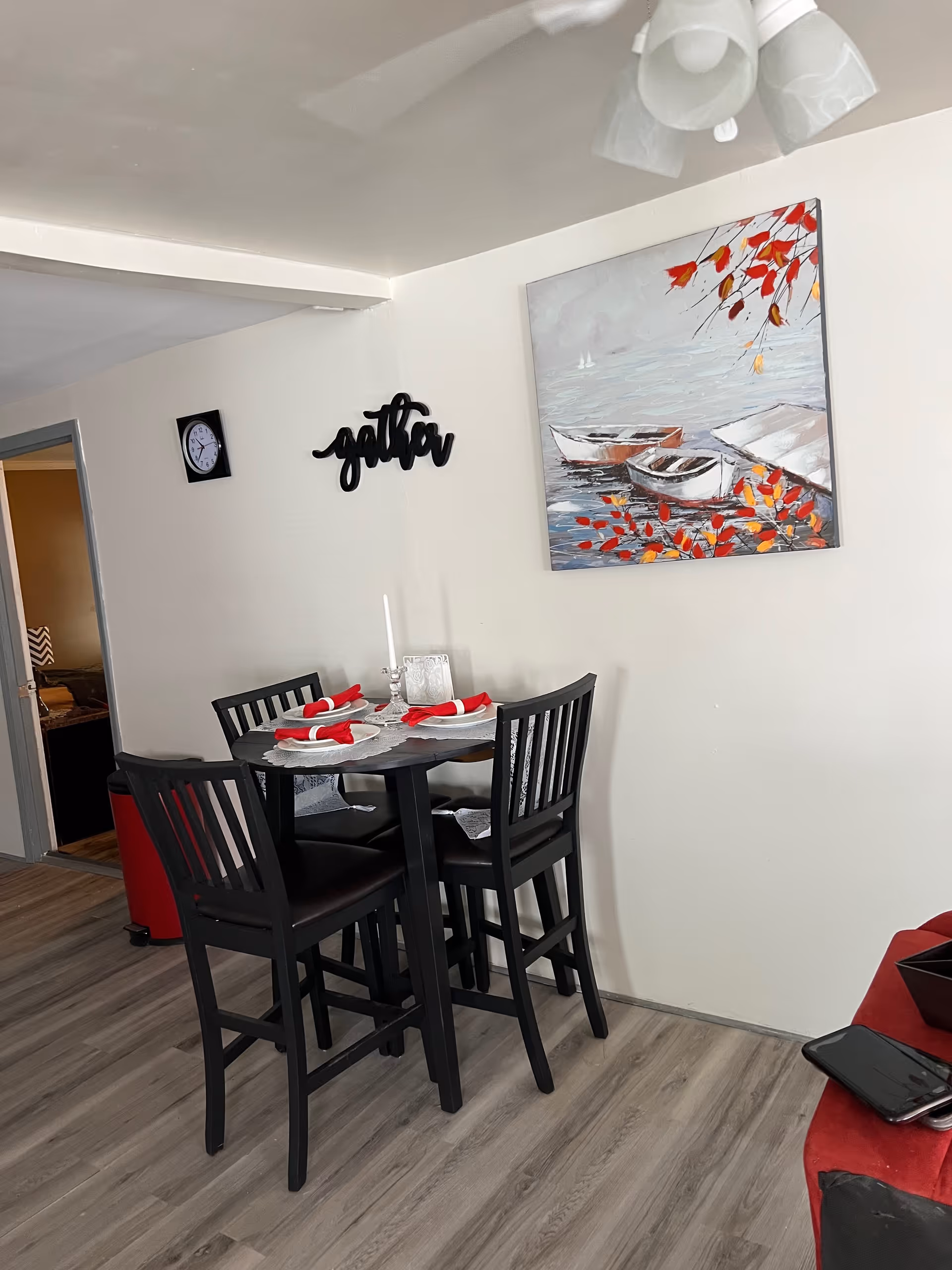 Small dining table with four chairs and place settings in a modern room.