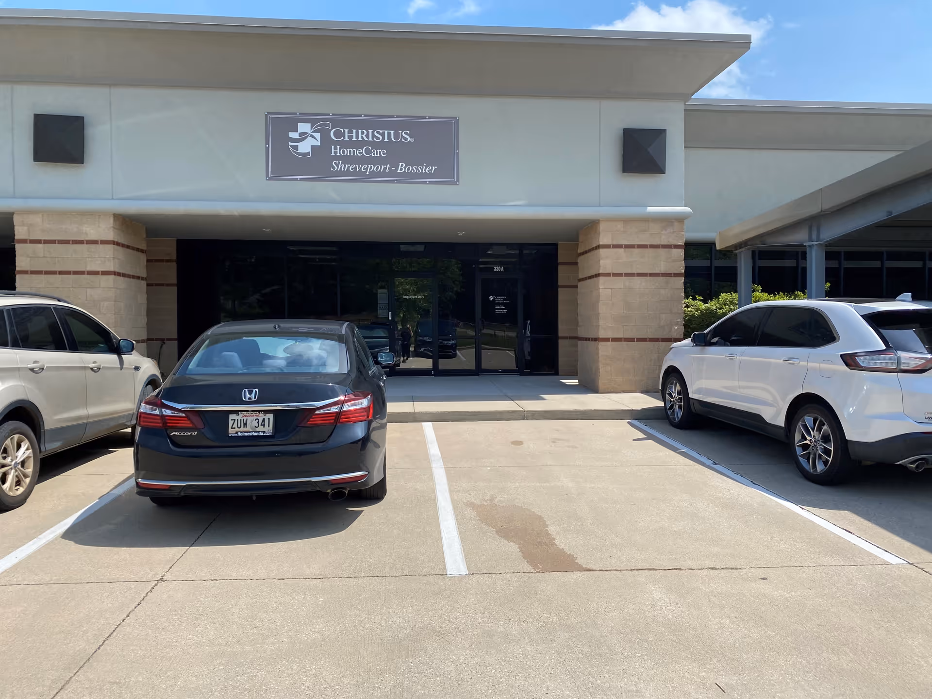Front exterior view of CHRISTUS HomeCare Shreveport-Bossier facility with parked cars.