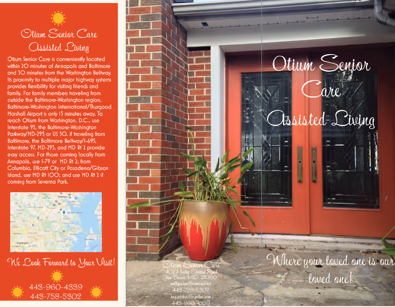 Red double front doors with decorative glass, a large red-and-gold planter with greenery on a stone entry, and a brochure-style text panel at left.