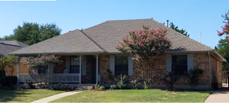 Single-story brick senior living facility with a front porch and manicured lawn.