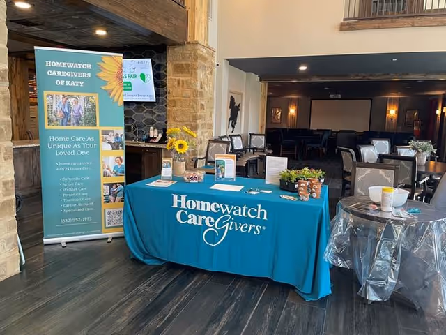 Lobby area featuring a turquoise Homewatch CareGivers table and banner.