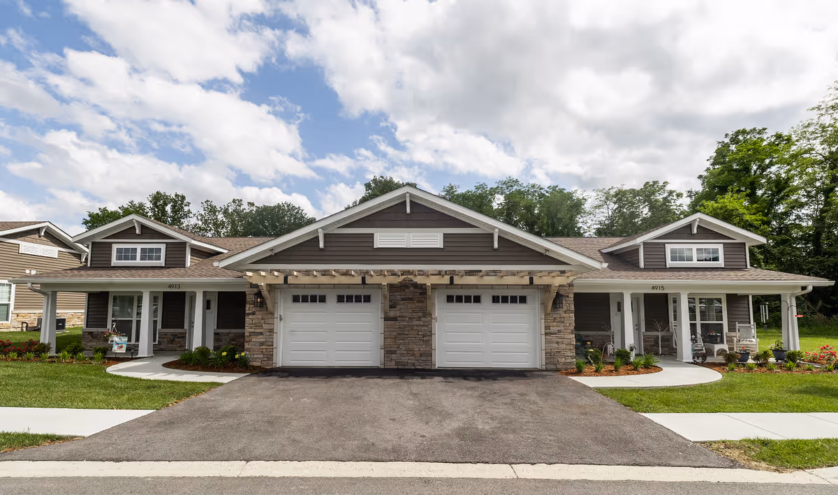 Rivercrest Senior Living exterior: residential-style building with two garage bays and front porches.