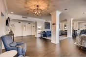 Spacious senior living lounge with blue chairs, sofas, and columns.