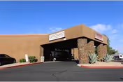 Exterior view of Coronado Healthcare Center entrance with stone columns and a parking lot.