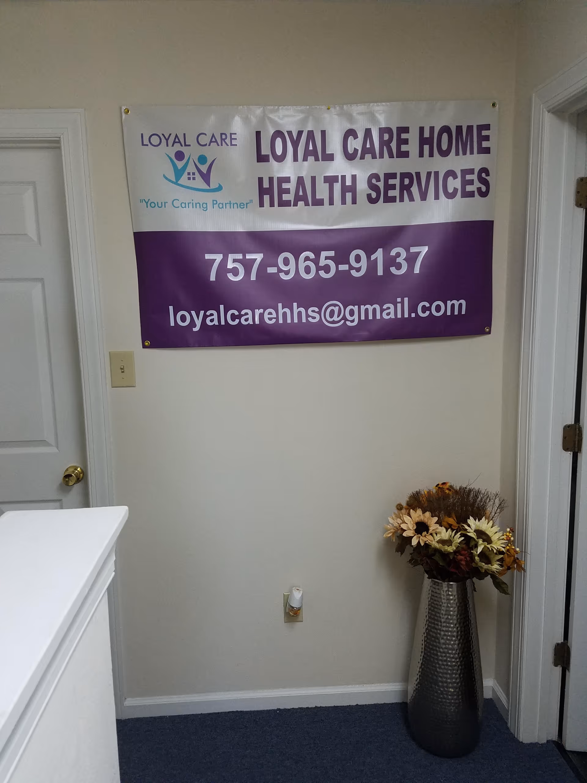 Indoor hallway featuring a Loyal Care Home Health Services banner on the wall.